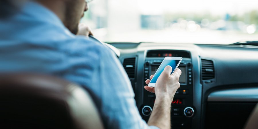 Man looking at phone while driving. 